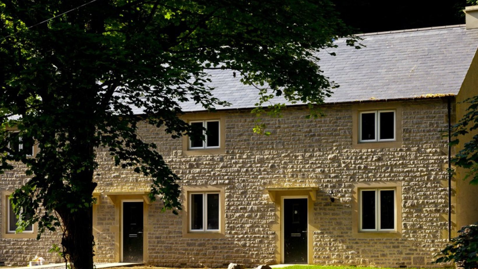 Stone cottages with behind large tree